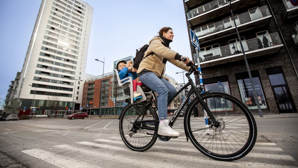 En kvinna cyklar i stadsmiljö.