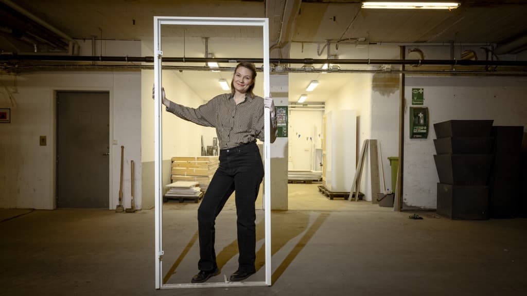 En kvinna håller i en dörrkarm