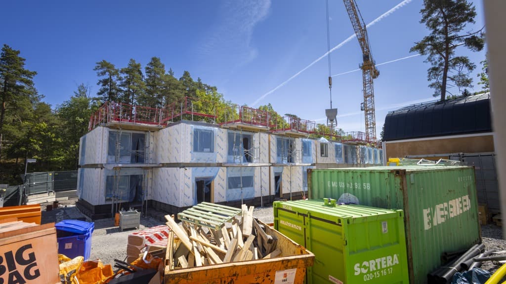 En byggarbetsplats med en lyftkran i bakgrunden.