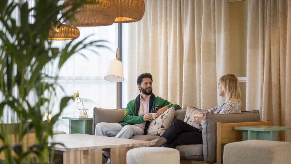 En man sitter i en soffa bredvid en kvinna.