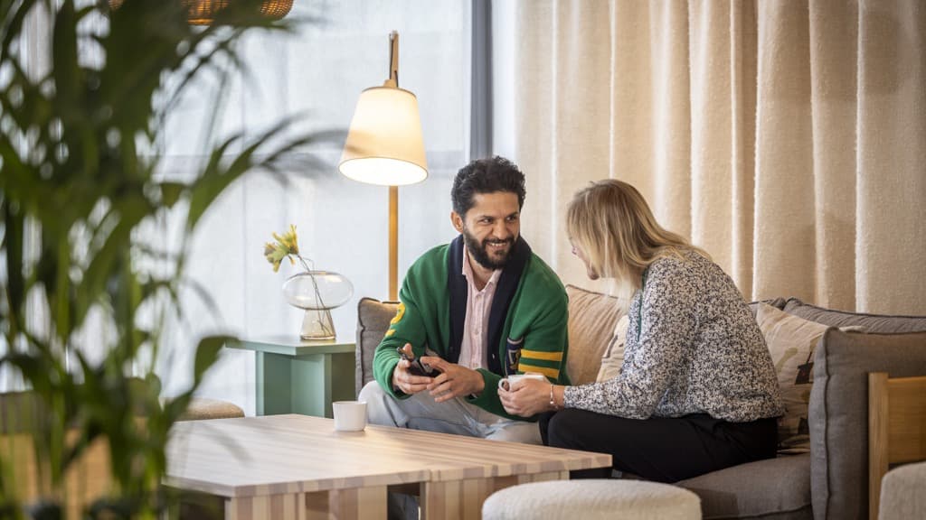 Två personer samtalar i en soffa.