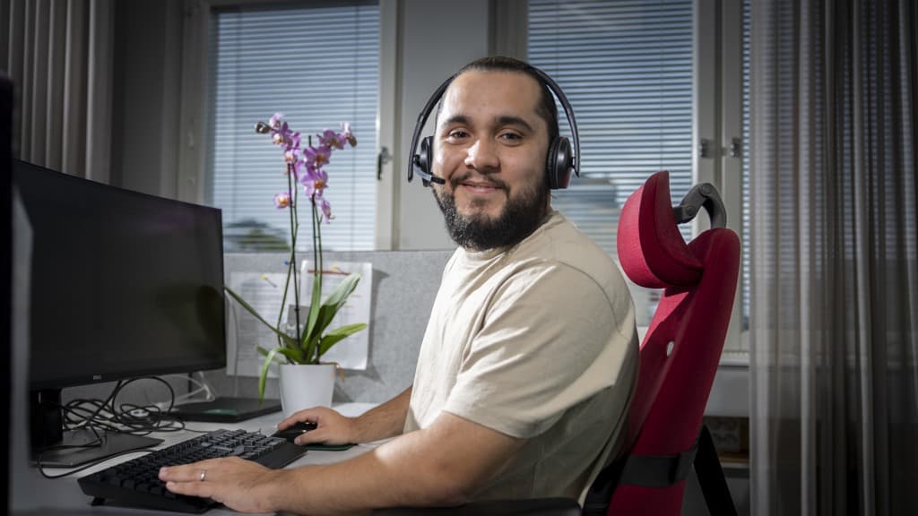 Man i kundservice sitter i en stol med headset på huvudet.