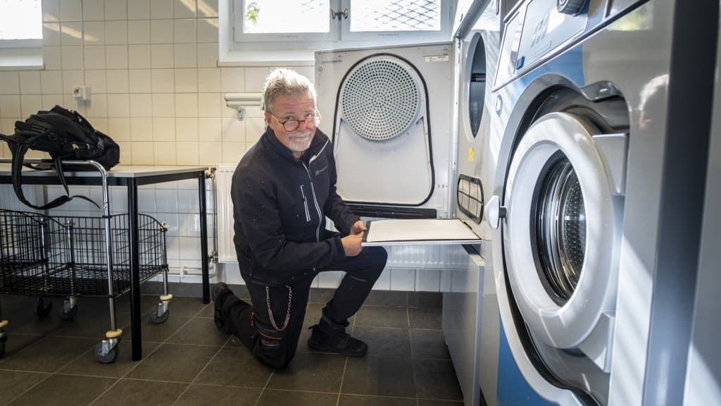 En man lagar en tvättmaskin.