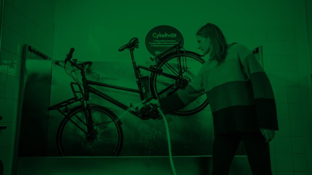 En kvinna tvättar en cykel.