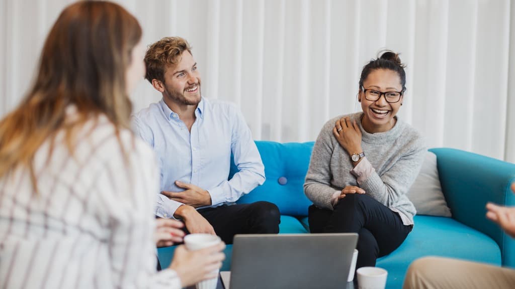 tre personer samtalar i en soffa.