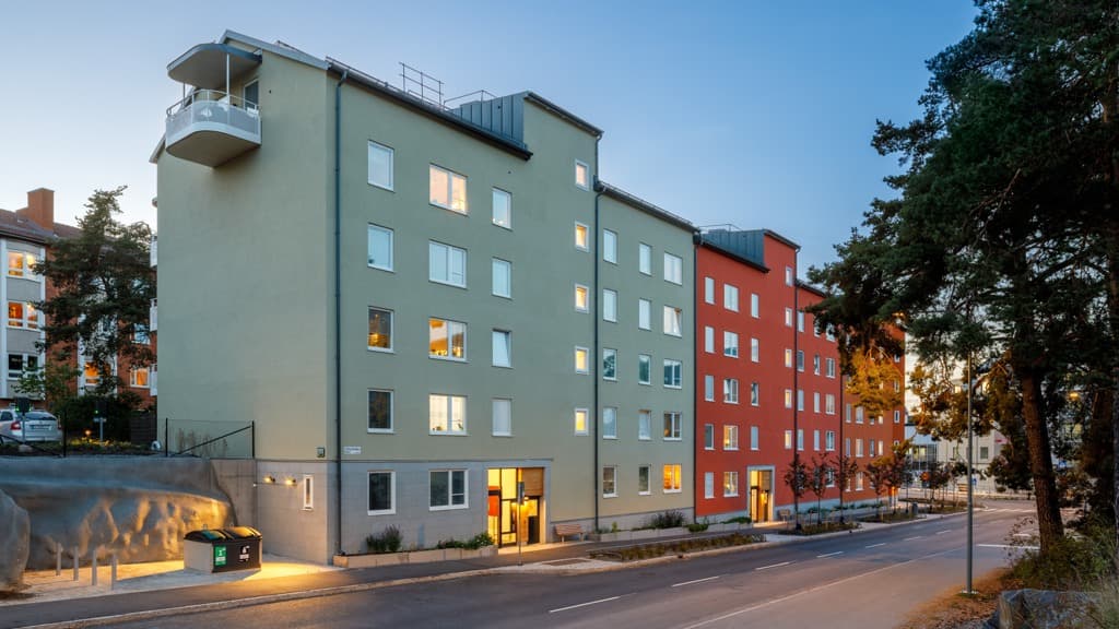 Ett hyreshus med många fönster på sidan av gatan.