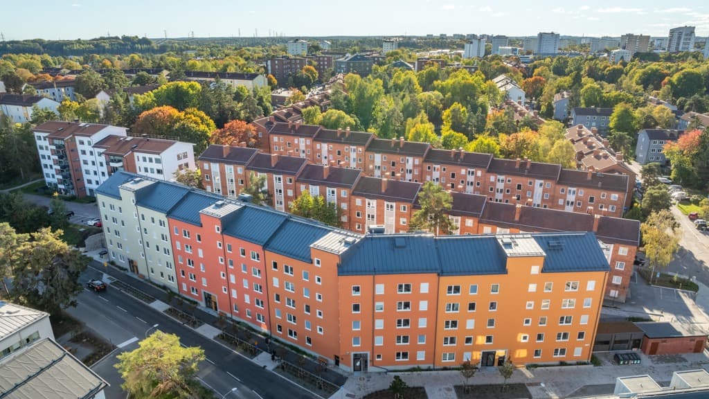 Stadskvarter med husfasader i orange, rött och grönt.