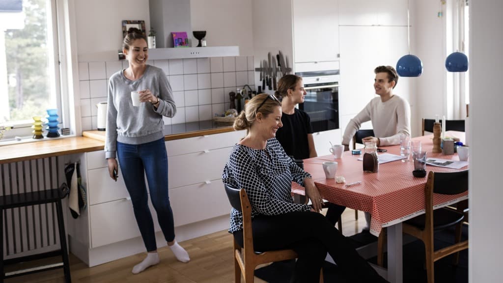 Fyra personer umgås i ett kök.