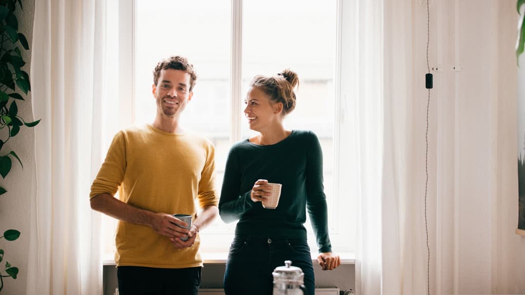 En man och en kvinna står framför ett fönster.