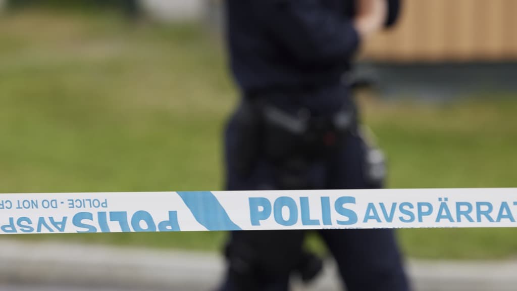 En polisman står bakom en polisavspärrning