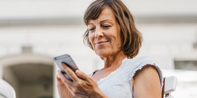 Kvinna som tittar på sin mobil