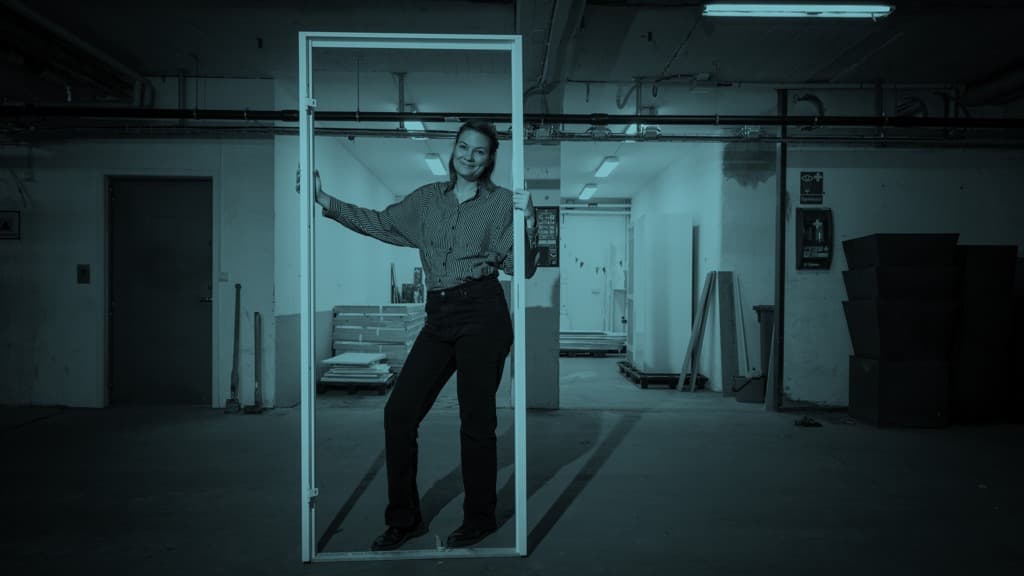 En kvinna håller i en dörrkarm.