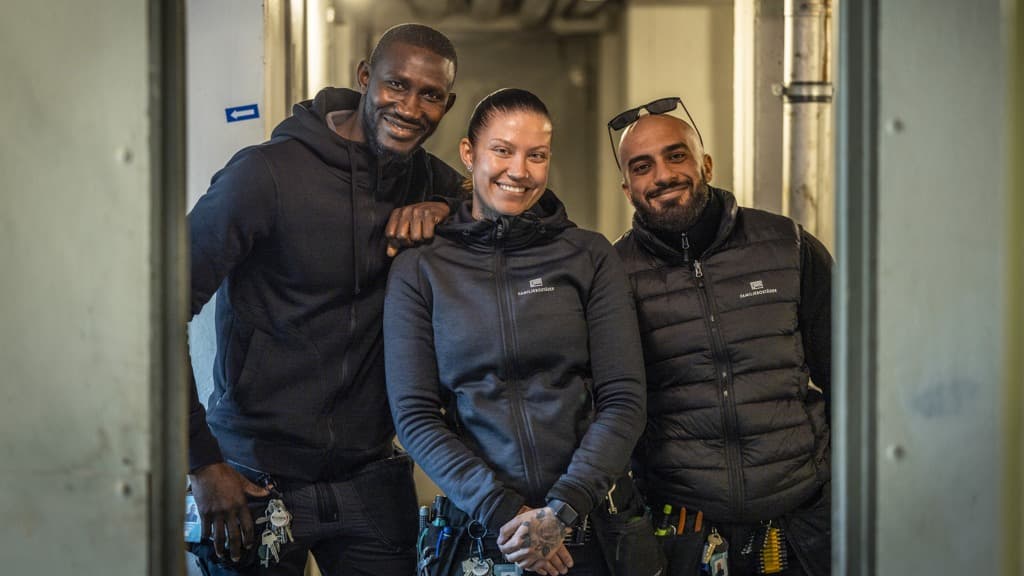 En grupp om tre personer som står bredvid varandra.