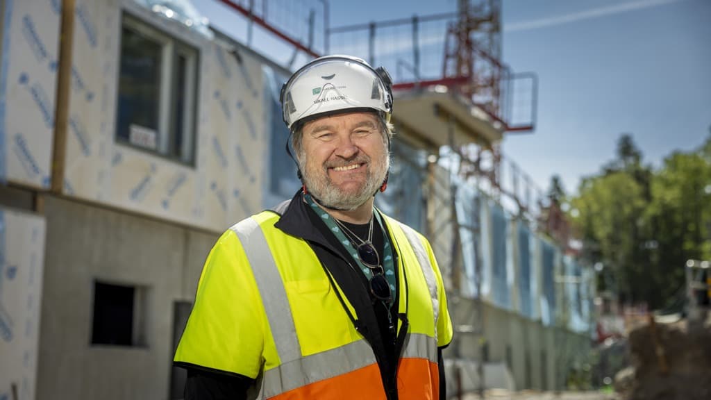 En man iförd skyddsväst och skyddshjälm.