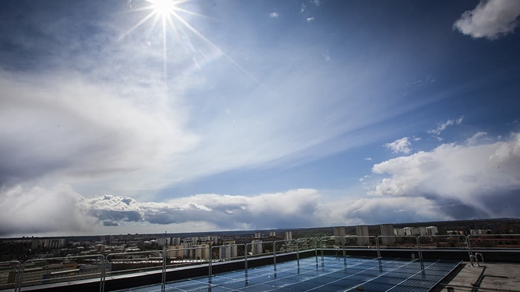 Solceller på tak med blå himmel bakom.