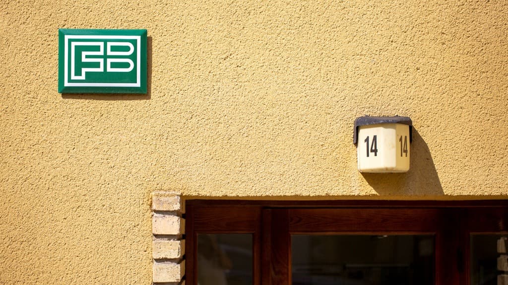 Gul husfasad med en Familjebostäderskylt.