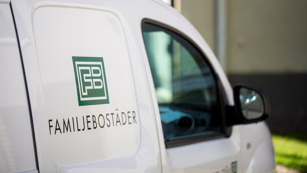 En vit skåpbil med en logotyp på sidan.