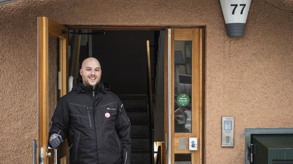 En man i svart jacka står i en dörröppning.