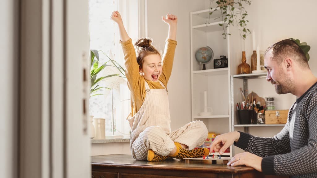 En man och en liten flicka sitter vid ett bord.