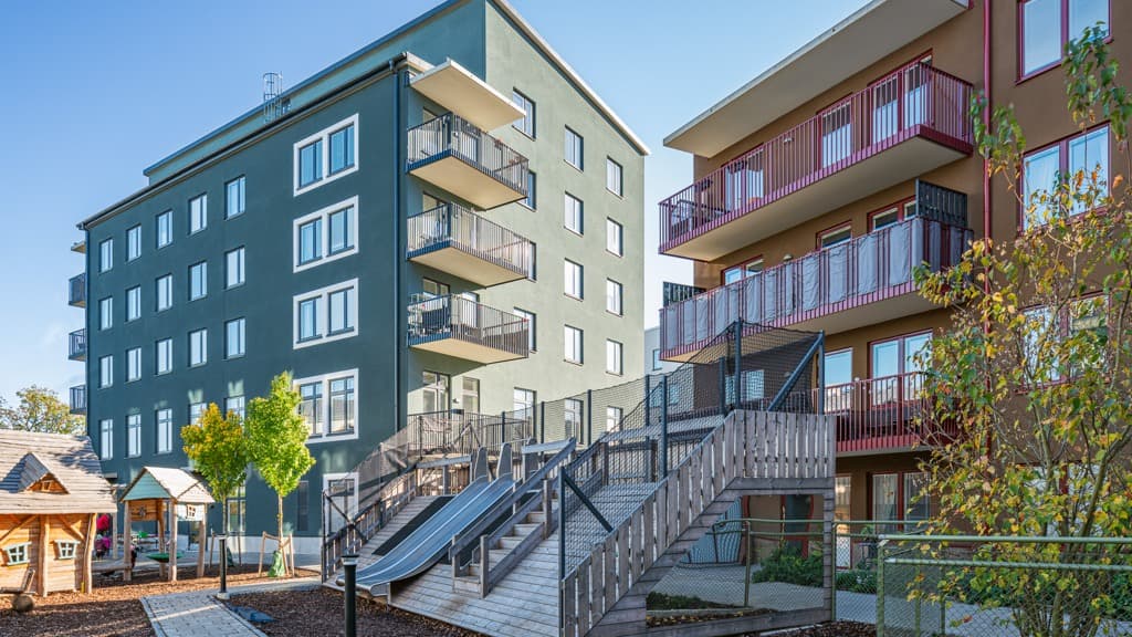 En grupp byggnader med en lekplats framför sig.