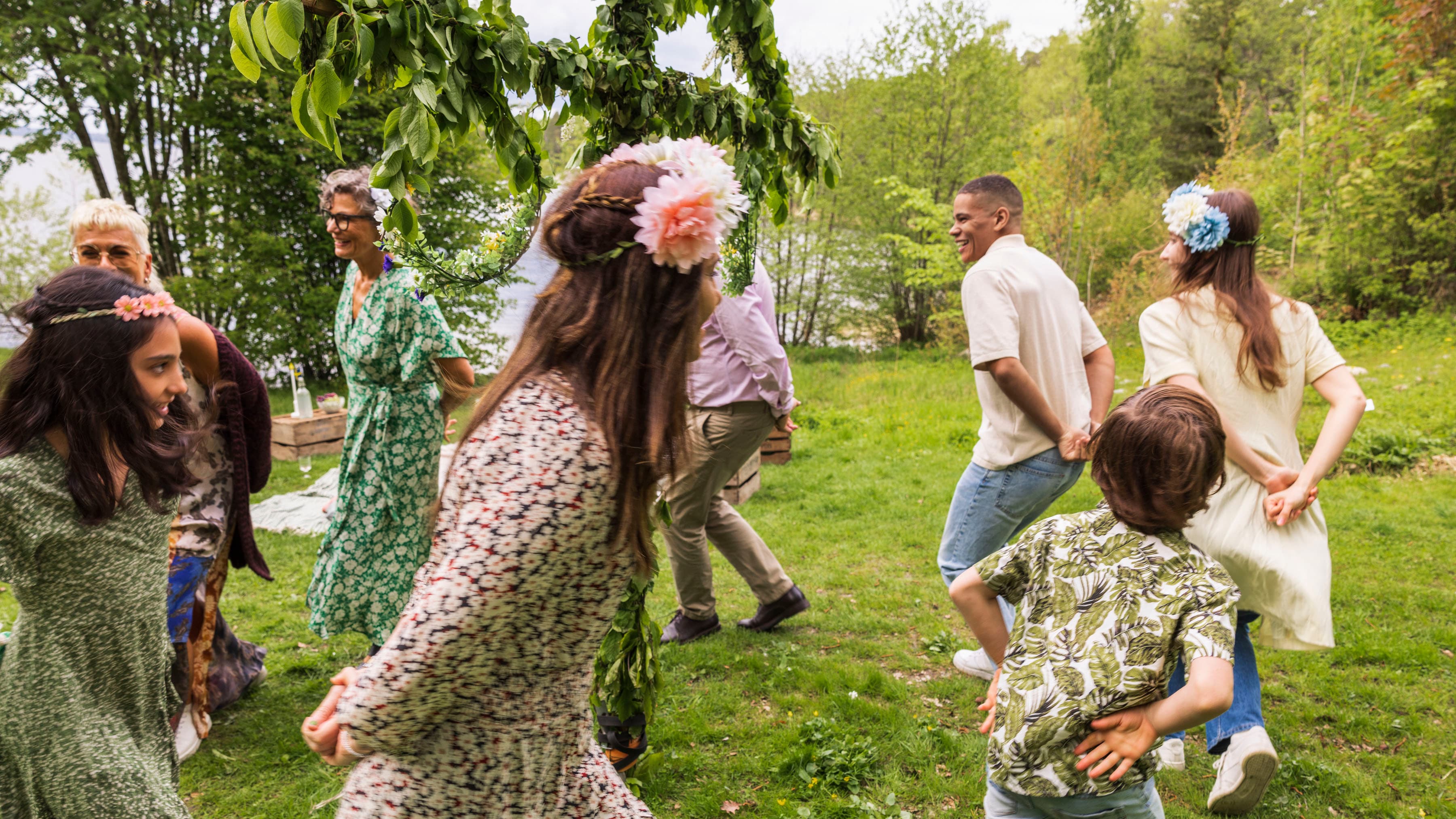 Barn och vuxna som dansar runt en midsommarstång