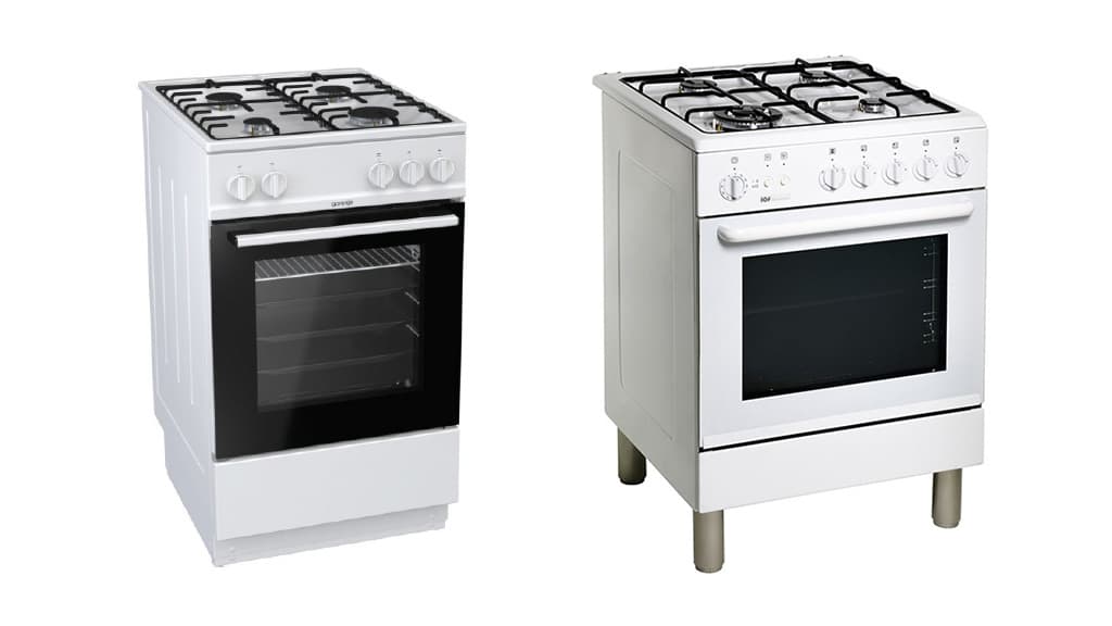 Två vita gasspisar med svart galler. Den bredare spisen har metallben.