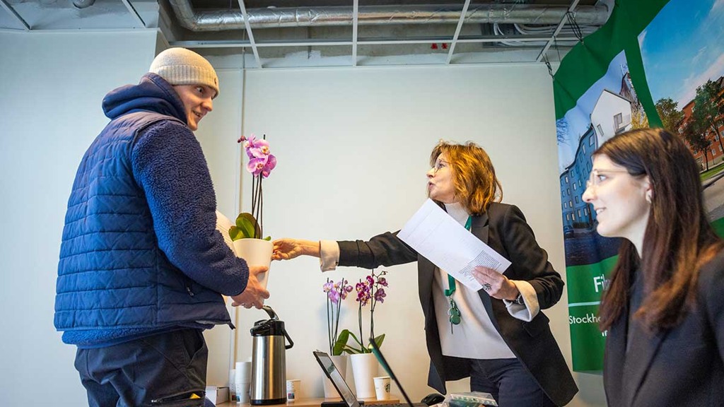 En man skakar hand med en kvinna vid ett skrivbord.