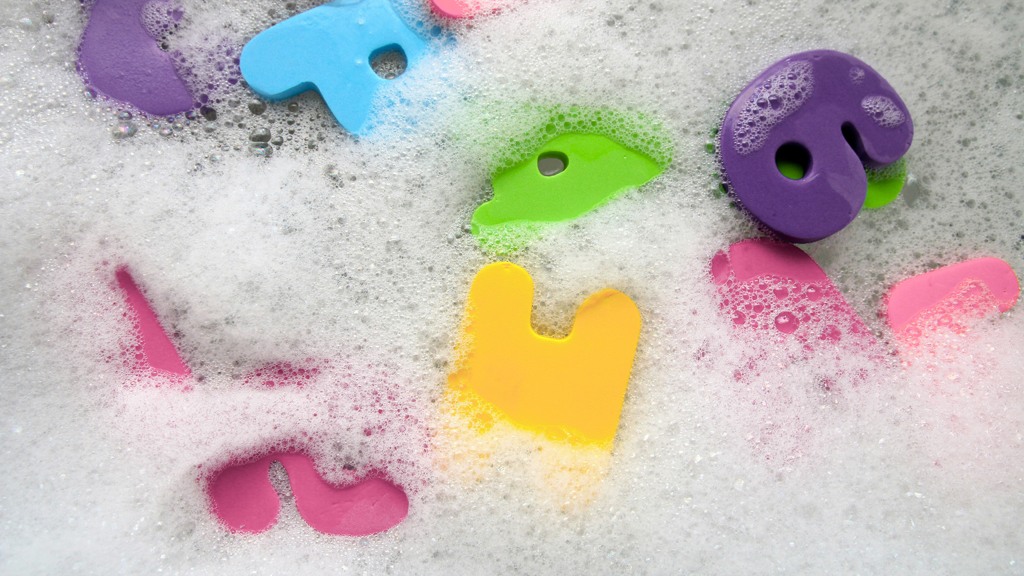 Diska plastleksaker i ljummet vatten och diskmedel , f&auml;rgglada leksaker i ett skumbad