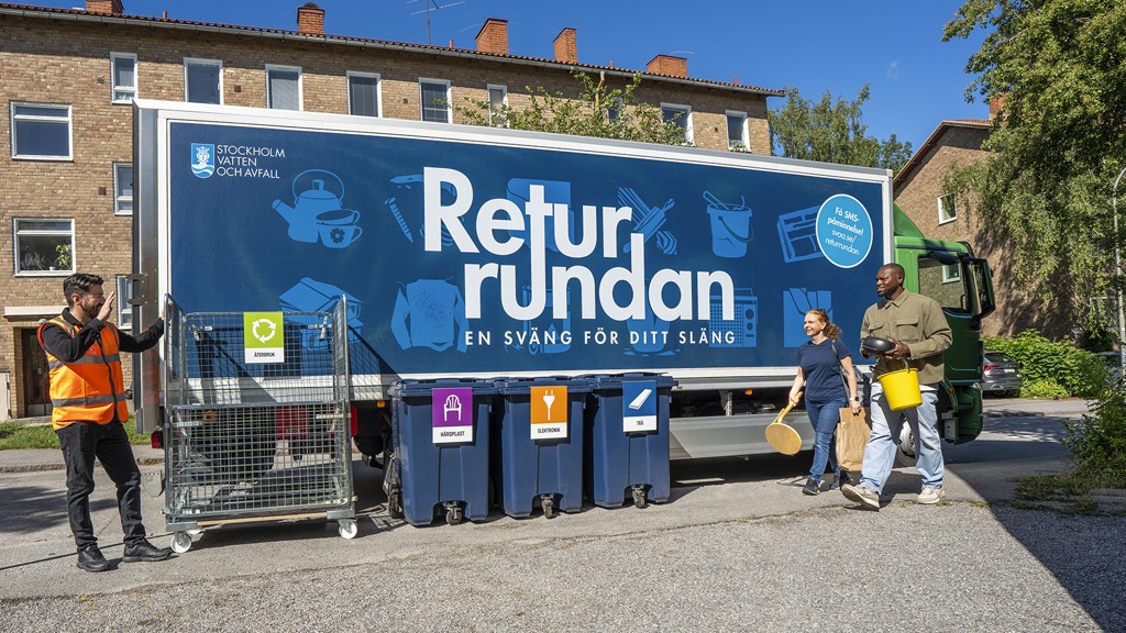 Den blå lastbilen Returrundan med personal i reflexväst och två besökare
