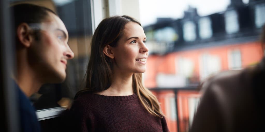 Man och kvinna tittar ut genom ett fönster
